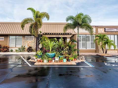 Store exterior decorated with many potted plants and other greenery